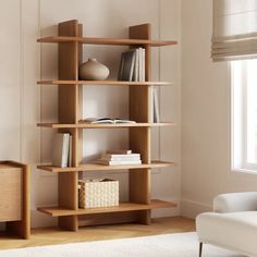 a living room with a white chair and book shelf