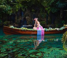 a woman in a pink and blue dress is sitting on a canoe