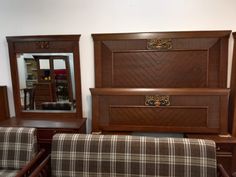 a living room filled with furniture next to a wall mounted mirror and wooden dressers