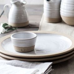 a white plate topped with two cups and saucers on top of a wooden table