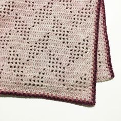 two crocheted squares on top of each other, one is pink and the other is white