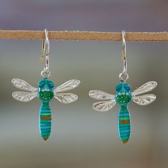 As if from an enchanted lagoon, these dragonflies arrive to infuse your days with serene energies. The Del Toro Family from Mexico sends a message of transformation through these resin dangle earrings, whose combination of blue, green and turquoise colors creates a unique illusion. The pieces are also accented with high-polished sterling silver. Animal Themed Jewelry, Green And Turquoise, Hand Painted Earrings, Painted Earrings, Painted Jewelry, Hand Painted Jewelry, Mens Jewelry Necklace, Green Jewelry, Flower Pendant Necklace