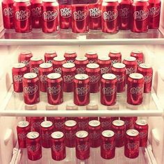 the refrigerator is filled with many red sodas