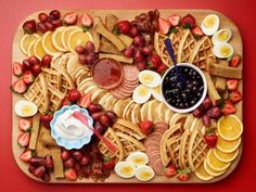 a platter with fruit, crackers, and other snacks on top of it