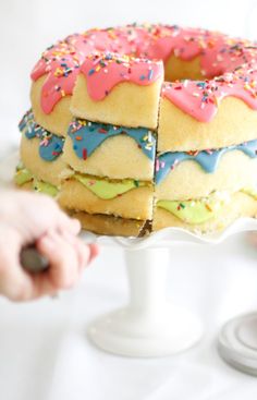 a cake with frosting and sprinkles cut into pieces on a plate