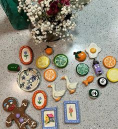 there are many different decorated cookies on the table next to a vase with flowers in it