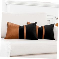 three black and brown pillows on a white couch