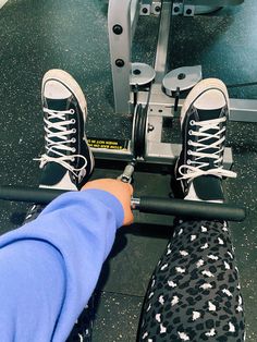 a person with their feet on a barbell in front of a gym equipment machine