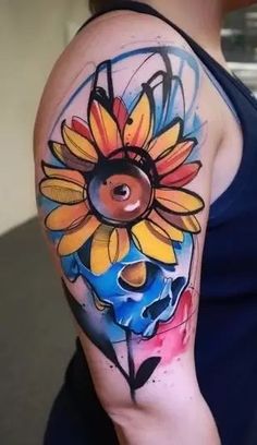 a woman's arm with a colorful tattoo on it and a sunflower in the center