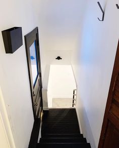 an open door leading to a hallway with black carpet