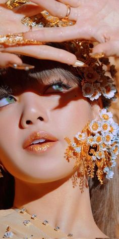 a woman with gold jewelry and flowers in her hair