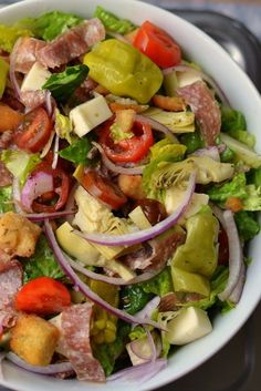 a white bowl filled with lots of different types of food on top of a table