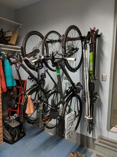 there is a bike hanging on the wall next to some skis and snowboards