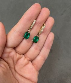 An immaculate pair of emeralds and diamond latch back earrings. Handcrafted in solid 14K yellow gold, these earrings feature two vivacious natural emerald cuts that are prong set and dropdown. Each emerald displays incredible color and clarity. Round diamonds accent the earrings. A latch back system is used in these earrings, they are secure and easy to manipulate. Earring Settings: Prong Set Gold Purity: 14K Yellow Gold Main Stone: Emerald Shape: Emerald Cut Luster: Excellent-Very Good Color: G Emerald Yellow Gold Diamond Earrings Fine Jewelry, Emerald Drop Earrings Fine Jewelry, Emerald Yellow Gold Diamond Earrings, Formal Yellow Gold Diamond And Emerald Earrings, Emerald Dangle Earrings Fine Jewelry, Gia Certified Emerald Diamond Earrings, Classic Emerald Diamond Earrings Gia Certified, 14k Gold Emerald-cut Gemstone Earrings, Luxury 14k Gold Emerald Cut Earrings