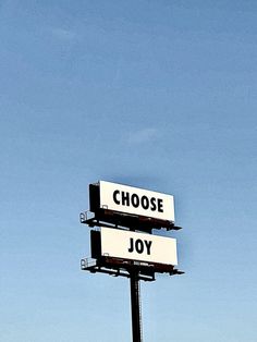 two billboards with the words choose joy and choose joy written on them against a blue sky