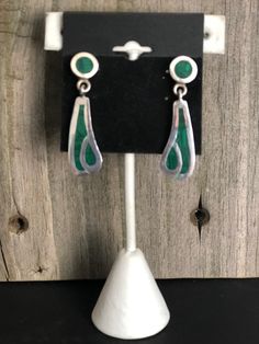 Malachite and Sterling Silver Earrings Southwestern Beautiful green Malachite is inlayed into Sterling Silver to create these gorgeous Southwestern-style earrings. The earrings come in two pieces connected together to create an attractive dangle drop style. These gorgeous earrings are finished off with post backs. They are stamped on the backs with the artisan's number, 925 (Sterling) and Mexico, denoting their country of excellent craftmanship. Length: 1-1/2 inches Width: 1/2 inch Weight: 12 gr Handmade Southwestern Green Earrings, Southwestern Green Sterling Silver Earrings, Southwestern Green Dangle Earrings, Green Southwestern Style Jewelry With Inlay, Southwestern Green Teardrop Earrings, Southwestern Style Green Inlay Jewelry, Nickel-free Green Southwestern Jewelry, Green Teardrop Southwestern Jewelry, Green Clip-on Dangle Jewelry