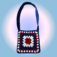 a crocheted bag with a blue handle and red, white and blue design