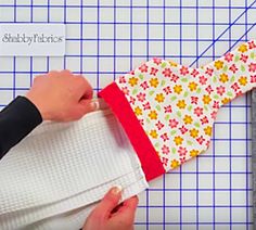 someone is cutting fabric on top of a piece of paper