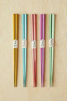 four colorful chopsticks are lined up on a table