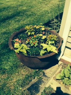 a planter filled with flowers sitting on the side of a house