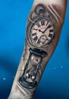 a man's arm with a clock tattoo on it