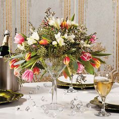 the table is set with champagne and flowers