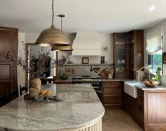 a large kitchen with marble counter tops and wooden cabinets, along with an island in the middle