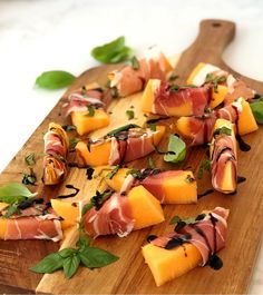 a wooden cutting board topped with lots of different types of food on top of it