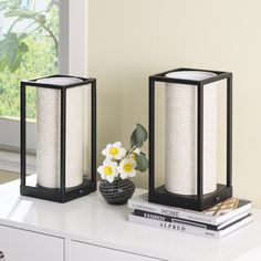 two black and white vases sitting on top of a table