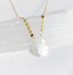 This is the perfect summer necklace! It’s features a white mother of pearl teardrop pendant that dangles between a row of 14kt gold filled tiny disks.  The chain is 14kt gold filled fine cable. The necklace is 17” and is finished with a spring ring clasp in my signature large end ring. White Teardrop Pendant Drop Necklace With Adjustable Chain, White Drop Necklace With Delicate Dangle Chain, White Minimalist Dangle Drop Necklace, Minimalist White Dangle Drop Necklace, White Delicate Dangle Drop Necklace, Minimalist Teardrop Pearl Chain Drop Necklace, White Dangle Drop Necklace With Adjustable Chain, White Long Drop Necklace With Adjustable Chain, Teardrop Pearl Charm Necklace In 14k Gold Filled