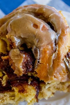 a close up of a doughnut with icing on a white plate and blue checkered table cloth