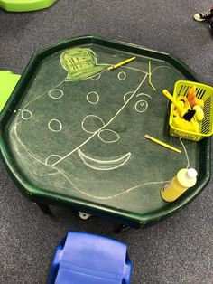 a child's play table with chalk drawings on it