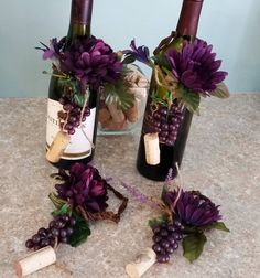 three wine bottles with purple flowers and corks