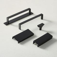 an assortment of black furniture on a white surface