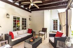 a living room with two couches and chairs in front of a ceiling fan that is hanging from the ceiling