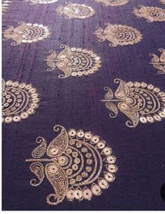 an intricately designed purple table cloth with gold paisley designs on it's edges