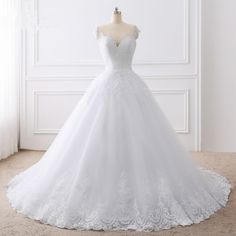 a white wedding dress on a mannequin stand in front of a wall with the words lover kiss