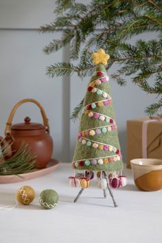 a small green christmas tree sitting on top of a table