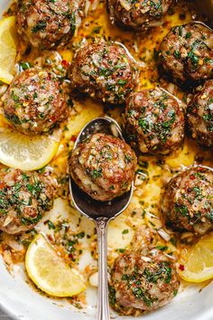 meatballs and lemons in a white bowl with a spoon