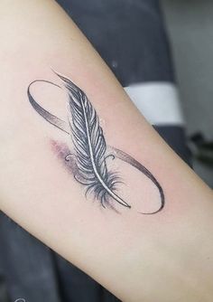 a woman's arm with a feather tattoo on it