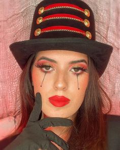 a woman wearing a hat and gloves with makeup on her face