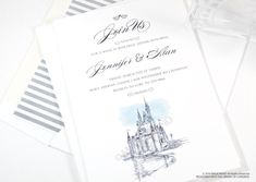 a wedding card with a drawing of a castle on the front and back, sitting on top of two envelopes