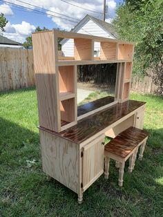 a wooden desk and bench sitting in the grass