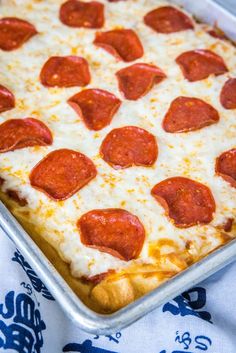 a pepperoni pizza sitting on top of a pan