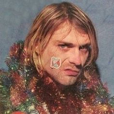 a man with an eye patch on his nose wearing a christmas sweater and tinsel