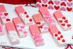 there are many pieces of pink and white cake on the table with hearts around them