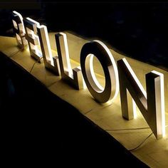 the illuminated sign for hilton hotel is lit up in front of it's entrance