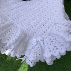 a white crocheted blanket with a bow on it