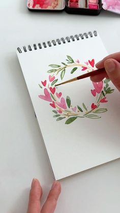 a person is painting flowers on a piece of paper