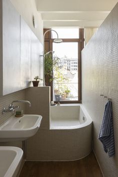 a bathroom with a tub, sink and window